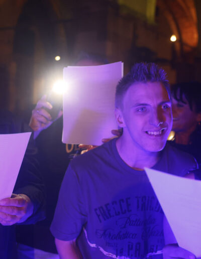 Gruppo di allievi che legge il testo di un brano durante un’esibizione serale del coro di ArteMusica Piacenza 2023/24