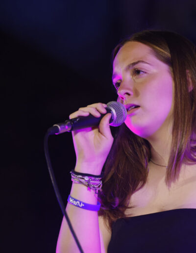 Giovane cantante che si esibisce al microfono durante un concerto di ArteMusica Piacenza