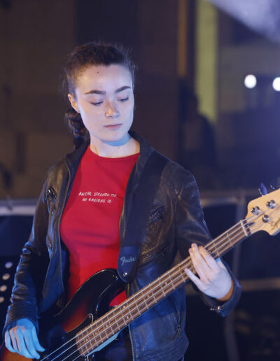 Giovane bassista di ArteMusica Piacenza che suona il basso durante un concerto serale