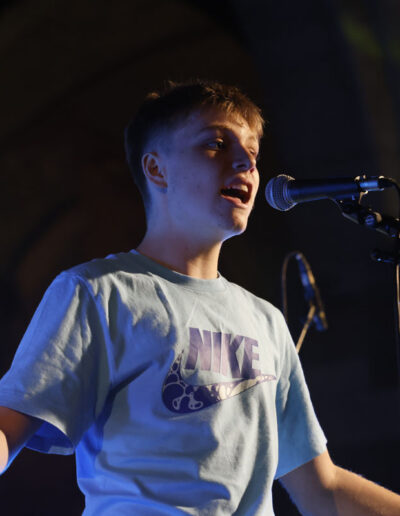 Giovane cantante di ArteMusica Piacenza che si esibisce al microfono durante il concerto serale