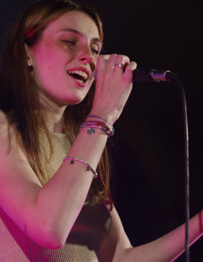 Giovane cantante di ArteMusica Piacenza che si esibisce dal vivo, ripresa mentre canta con espressione intensa