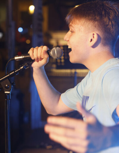Giovane cantante di ArteMusica Piacenza che si esibisce al microfono durante il concerto serale
