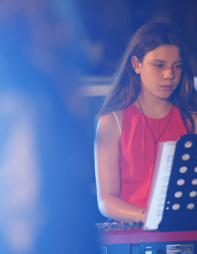 Giovane pianista di ArteMusica Piacenza che suona la tastiera durante un’esibizione serale