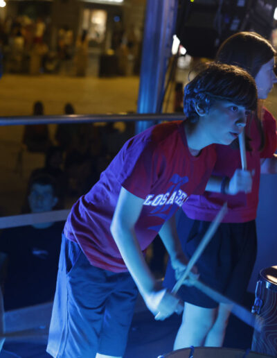 Gruppo di ragazzi di ArteMusica Piacenza che suonano le percussioni durante un’esibizione serale