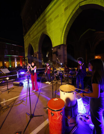 Band di giovani musicisti in concerto serale sotto i portici durante la stagione 2023/24 di ArteMusica Piacenza