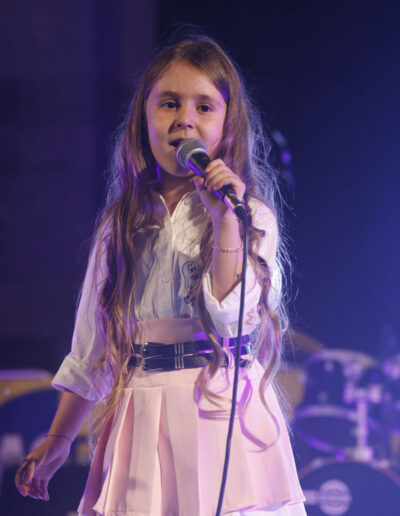 Bambina che canta al microfono durante un concerto