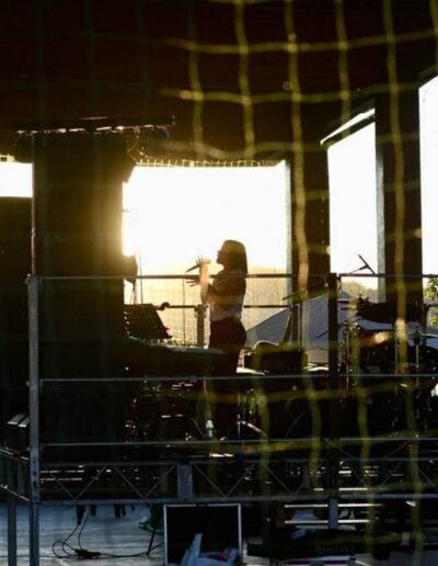 Cantante sul palco in controluce mentre si esibisce al tramonto durante un evento live