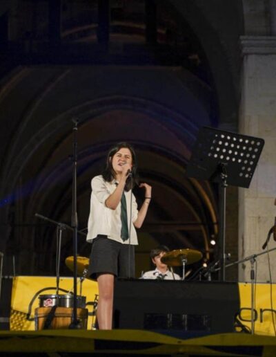 Giovani musicisti si esibiscono sul palco al Palazzo Gotico durante un concerto serale