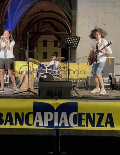 Band giovanile si esibisce sul palco a Piacenza con cantante, tastierista, chitarristi e batterista