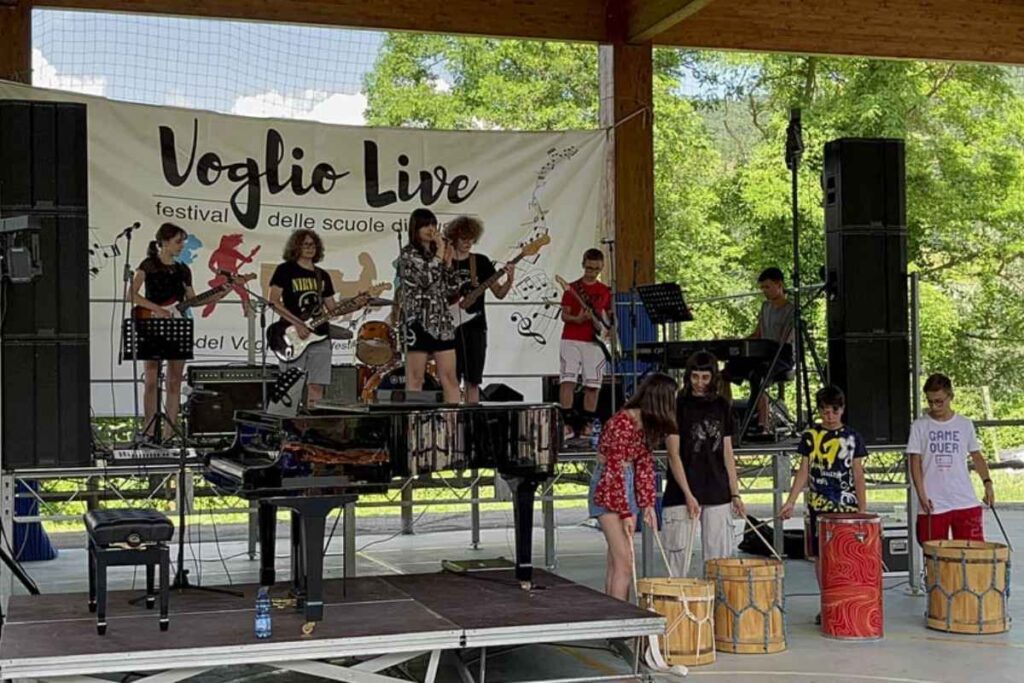 Gruppo di studenti che suonano dal vivo al festival Voglio Live su un palco all’aperto