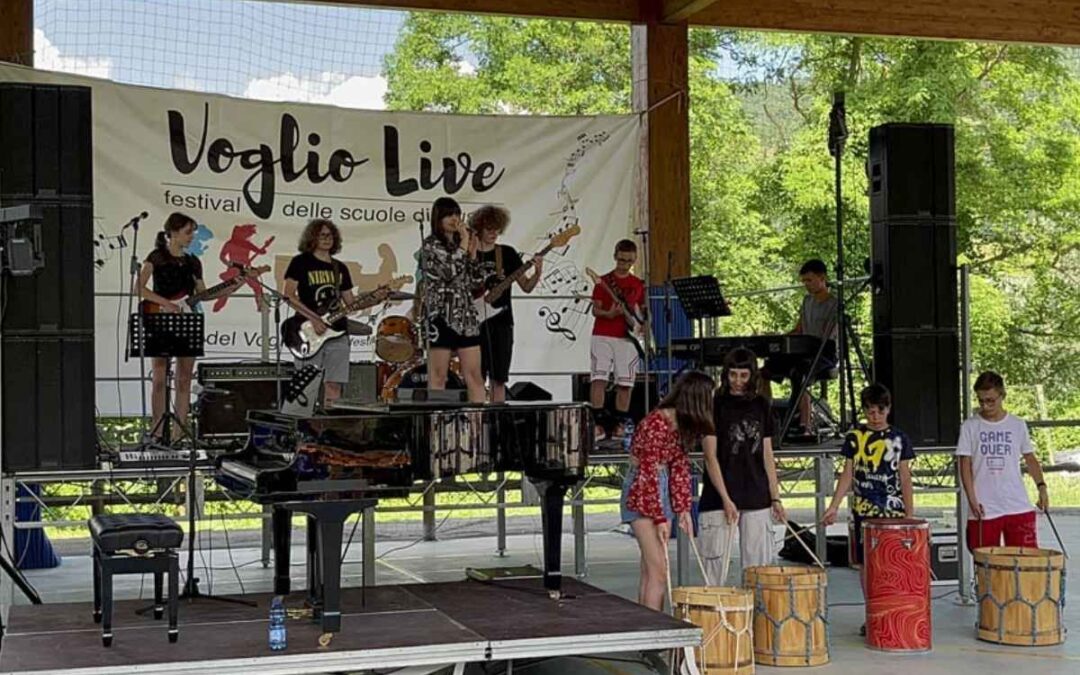 Gruppo di studenti che suonano dal vivo al festival Voglio Live su un palco all’aperto