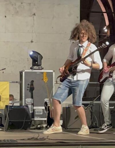 Due giovani chitarristi suonano dal vivo su un palco a Piacenza durante un concerto rock