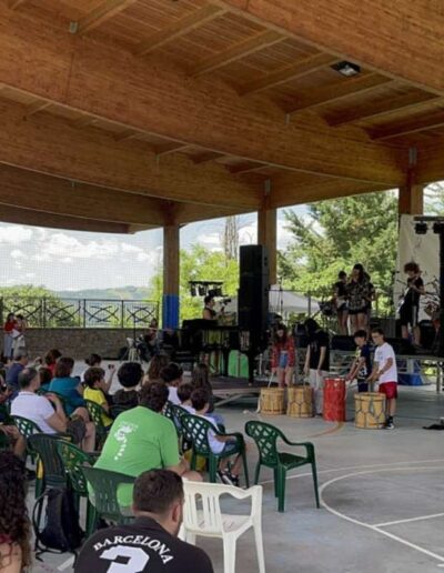 Pubblico che assiste all’esibizione degli studenti al festival Voglio Live sotto una struttura all’aperto