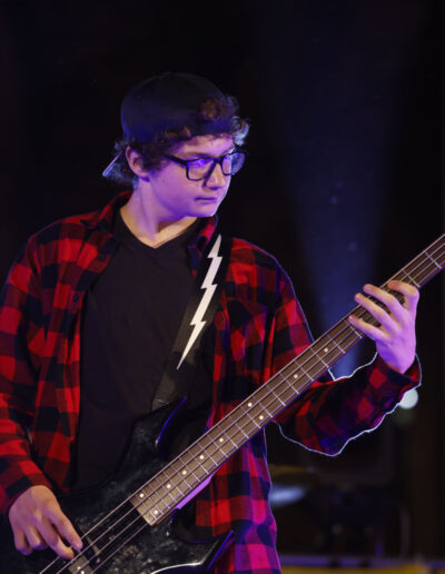 Giovane bassista suona dal vivo durante un concerto serale