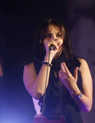 Giovane cantante si esibisce dal vivo durante un concerto serale