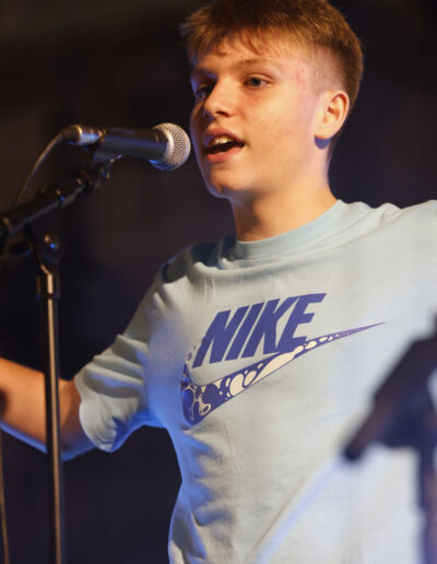 Giovane cantante che si esibisce al microfono durante una performance live