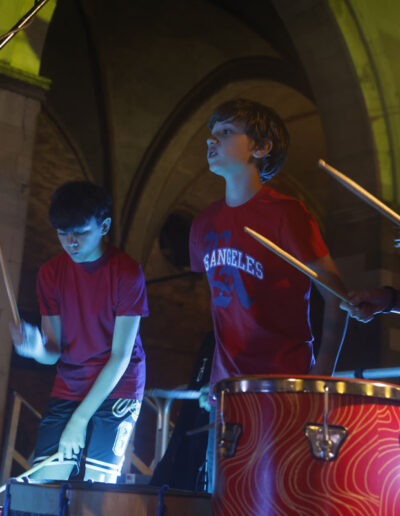 Giovani percussionisti di ArteMusica Piacenza che suonano sul palco durante un concerto serale