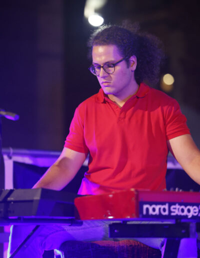 Giovane pianista suona la tastiera durante un concerto serale