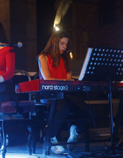 Due giovani pianiste di ArteMusica Piacenza suonano le tastiere durante un concerto serale
